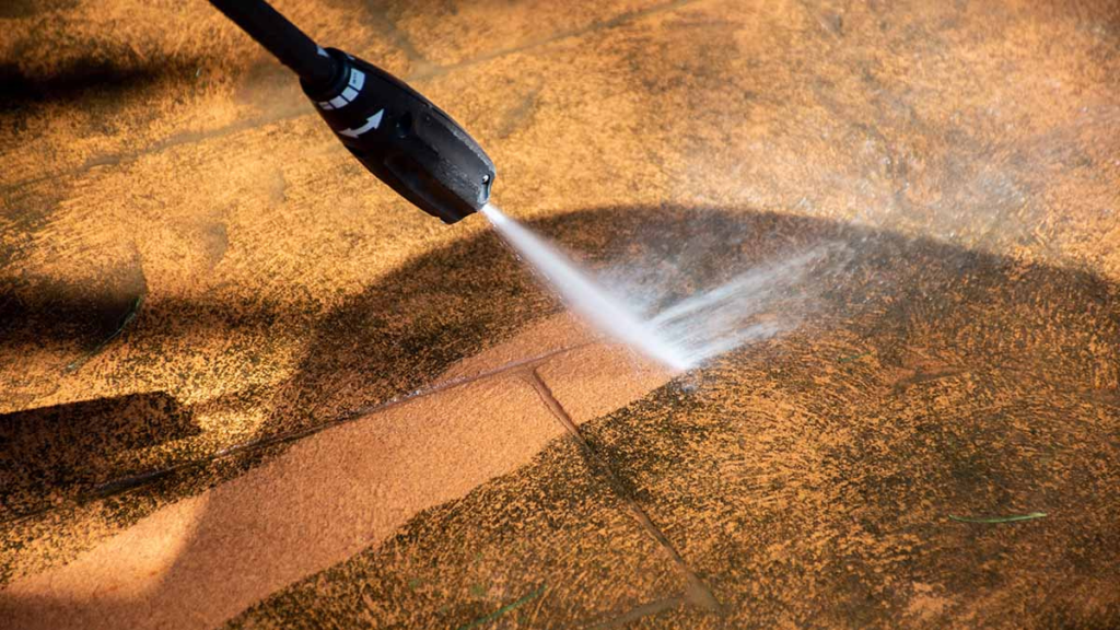 Nettoyeur haute pression utilisé pour nettoyer une terrasse extérieure et enlever les salissures incrustées